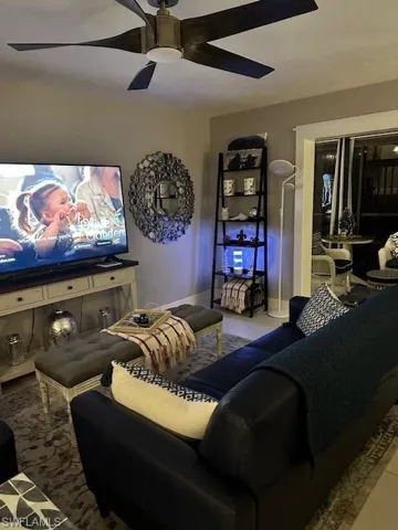Living area featuring ceiling fan and baseboards