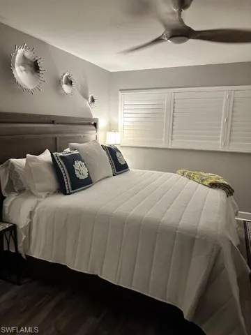 Bedroom with ceiling fan and dark wood finished floors