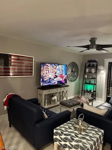 Living area featuring a ceiling fan and baseboards