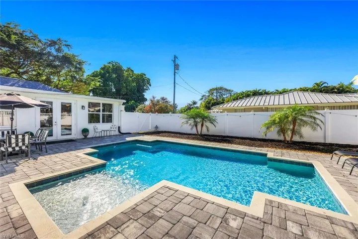 View of swimming pool featuring french doors, patio surround, and a fenced backyard