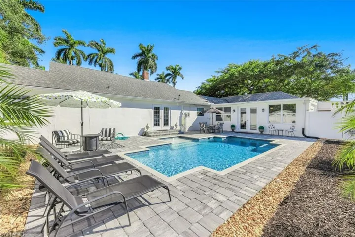 View of swimming pool with french doors, patio surround, and outdoor dining area