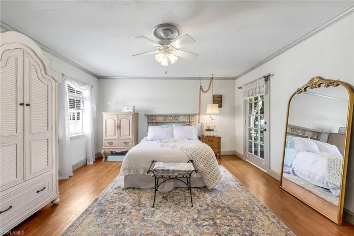Bedroom featuring crown molding, light wood floors, multiple windows, and a ceiling fan