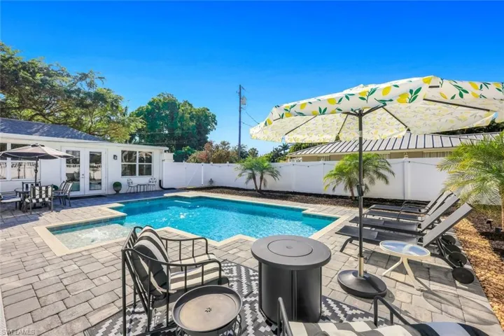 View of pool featuring french doors, patio surround, a fenced backyard, and outdoor dining space