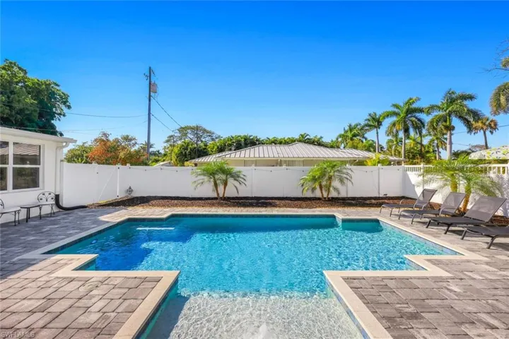 View of swimming pool featuring patio surround and a fenced backyard