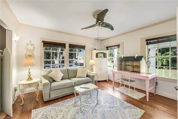 Living area with crown molding, wood flooring, and a ceiling fan