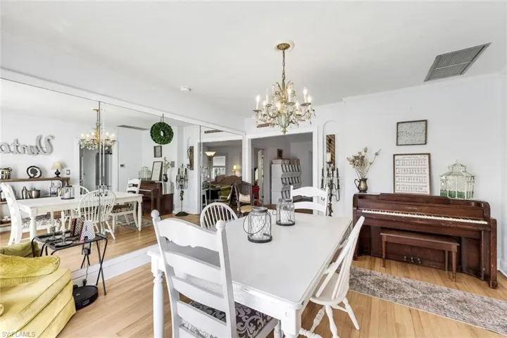 Dining space featuring hanging lights, light wood floors, and crown molding