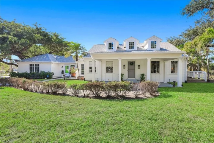 View of front facade featuring a front yard and covered porch