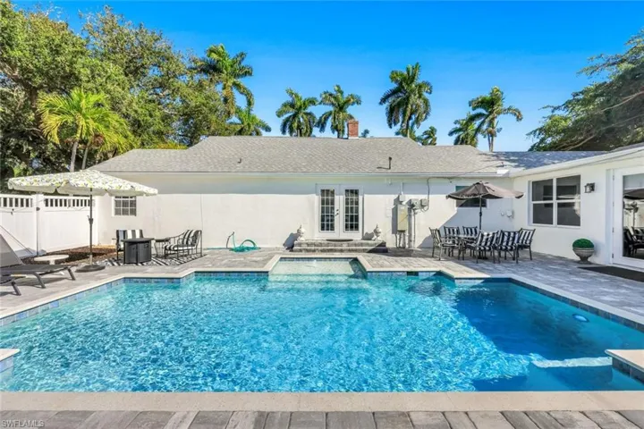Swimming pool with french doors and a patio