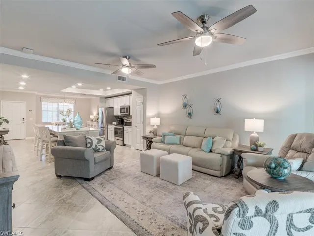 Living room featuring ceiling fan and ornamental molding
