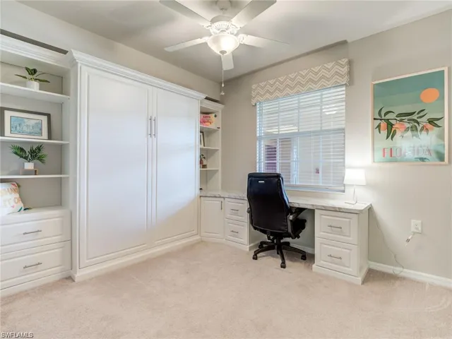 Carpeted office space featuring ceiling fan