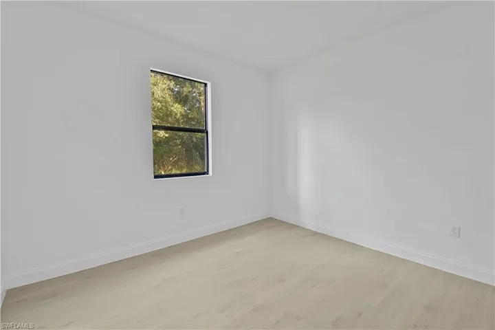 Unfurnished room featuring wood finished floors and baseboards