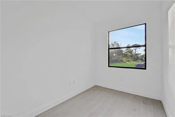 Unfurnished room with baseboards and light wood-type flooring