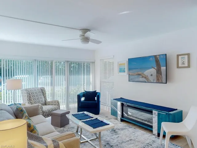 Living room with hardwood / wood-style floors, ceiling fan, and a wealth of natural light