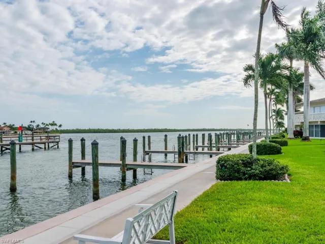 Dock area with a water view and a yard