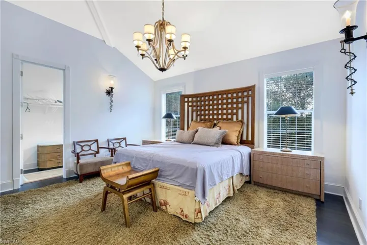 Bedroom featuring a chandelier, lofted ceiling, and wood finished floors