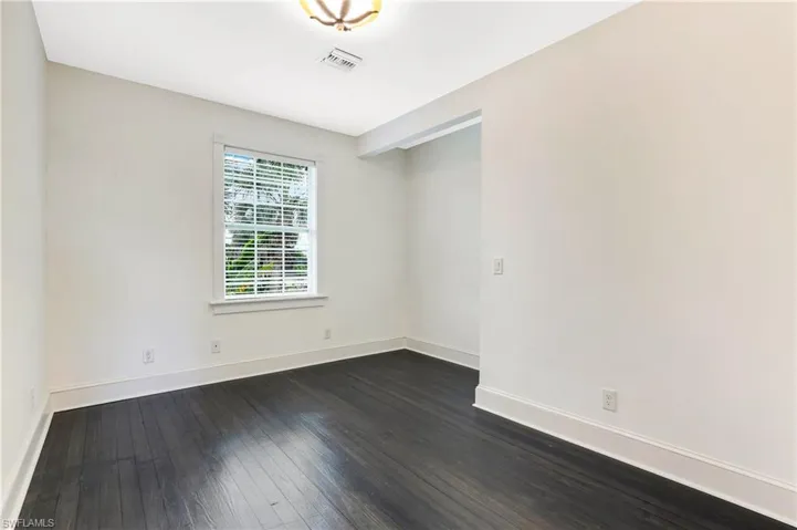 Spare room with dark wood finished floors and baseboards