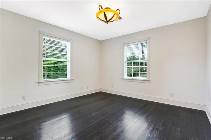 Unfurnished room with dark wood-style flooring