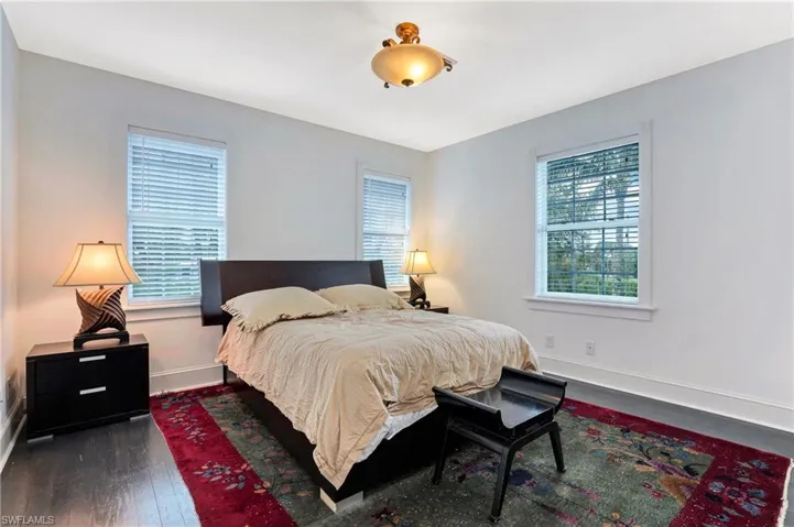 Bedroom featuring dark wood-type flooring and baseboards