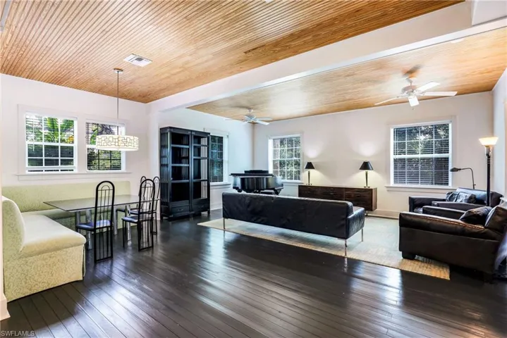 Living room featuring dark wood-style flooring and wood ceiling