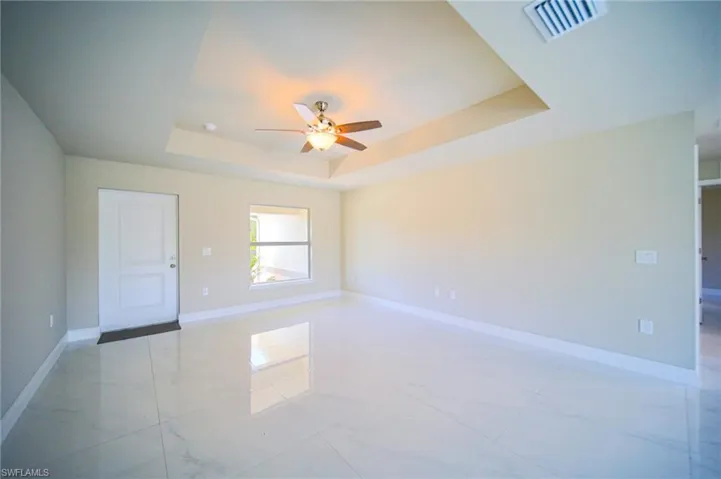 The Large Living Room Has A Tray Ceiling, Large Porcelain Tiles, And Plenty Of Natural Light!