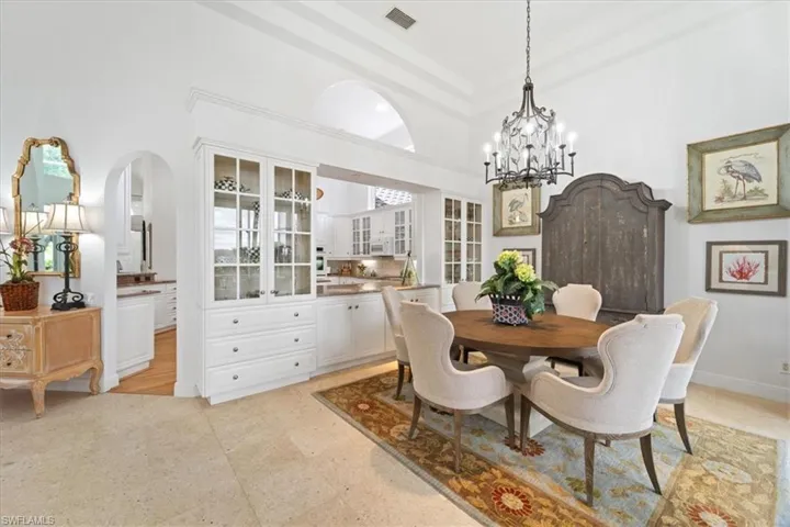 Dining room with a high ceiling, arched walkways, and a chandelier