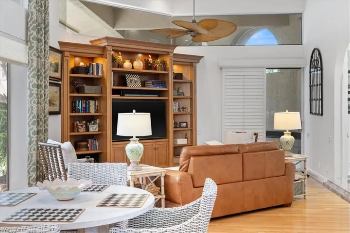 Living area featuring a ceiling fan, light wood-type flooring, and a high ceiling