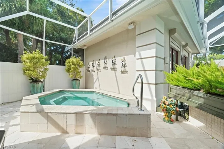 View of swimming pool featuring a lanai, a patio area, an in-ground hot tub, and a sunroom