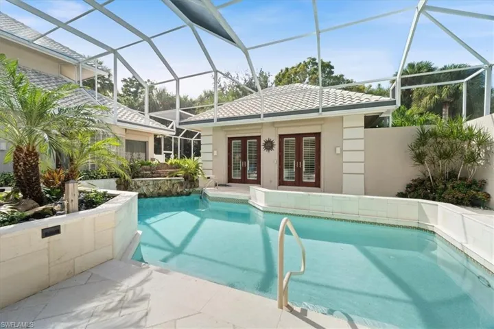 Swimming pool with a patio, a sunroom, a lanai, and french doors