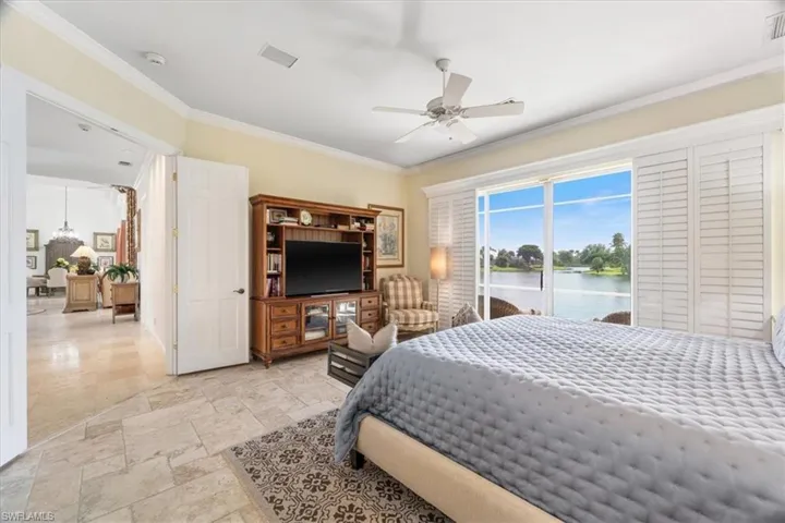 Bedroom featuring crown molding, ceiling fan, access to outside, and stone tile flooring