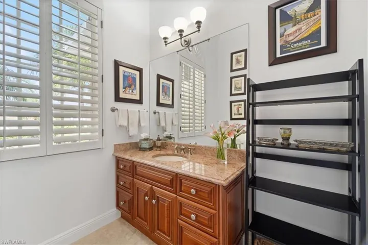 Bathroom featuring vanity, light tile patterned flooring, and a chandelier