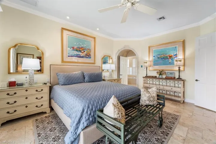 Bedroom featuring ornamental molding, ceiling fan, stone tile flooring, recessed lighting, and arched walkways