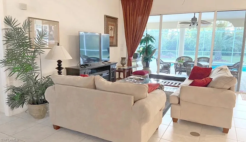 Living room featuring ceiling fan and light tile flooring