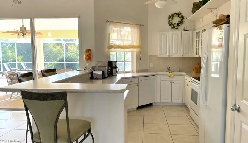 Kitchen featuring white cabinetry, ceiling fan, and plenty of natural light