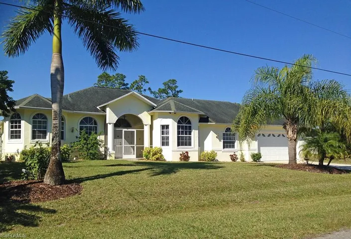 View of front of property with a garage and a front yard