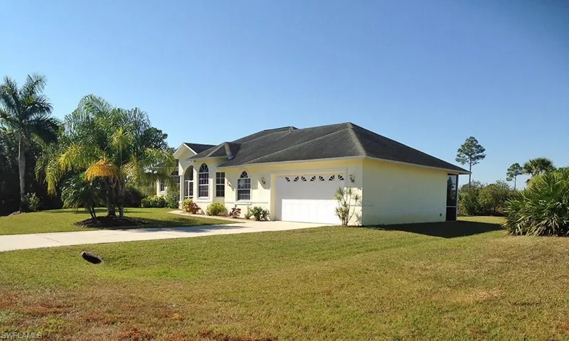 Ranch-style home with a front yard and a garage