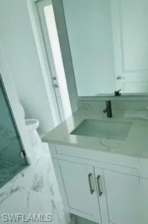 Bathroom with vanity, tile patterned floors, and toilet