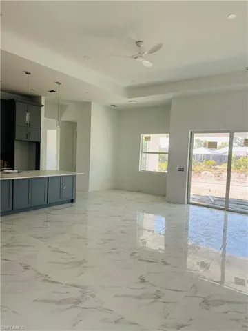 Unfurnished living room with ceiling fan and light tile flooring