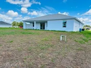 Rear view of property with a yard