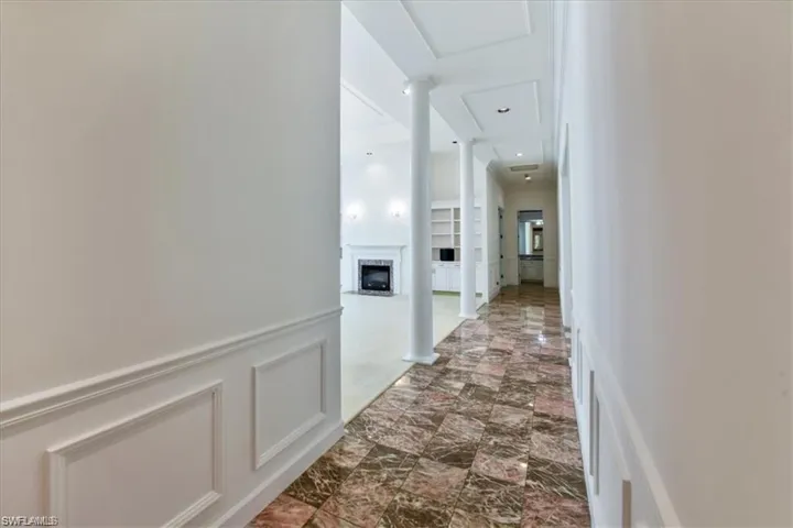 Hallway with tile flooring and decorative columns