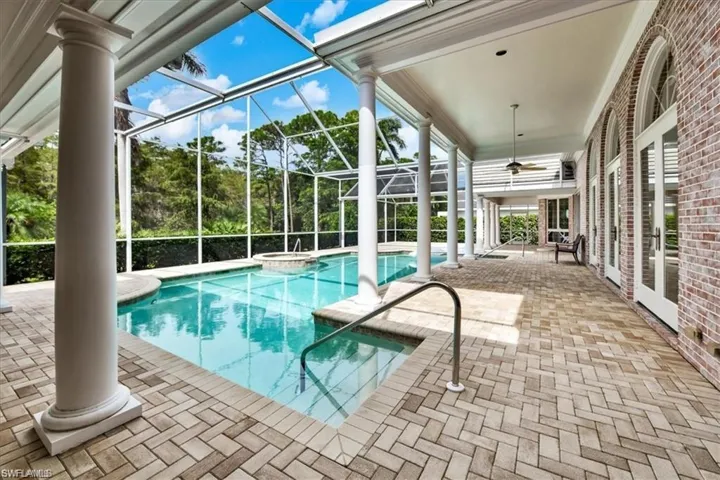 View of pool featuring an in ground hot tub, a patio, a lanai, and ceiling fan