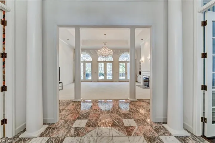 Hall featuring an inviting chandelier and tile flooring