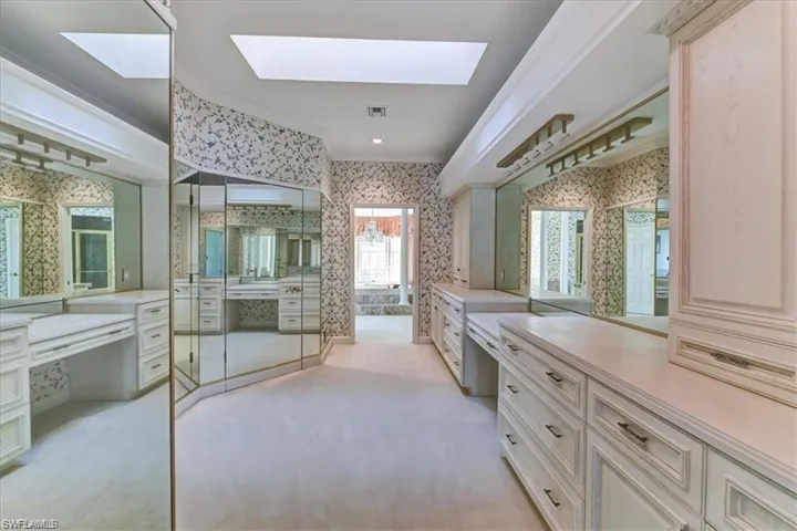 Bathroom featuring crown molding, a skylight, and vanity