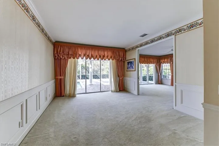 Spare room featuring a healthy amount of sunlight, ornamental molding, and carpet flooring