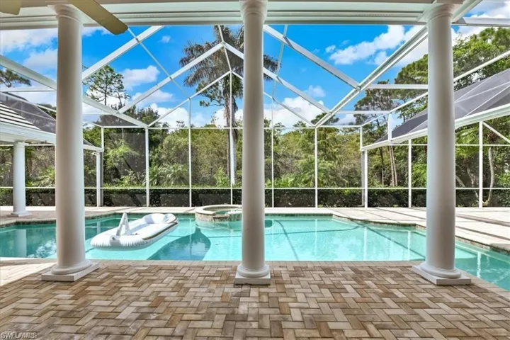 View of swimming pool featuring an in ground hot tub, a patio, and a lanai