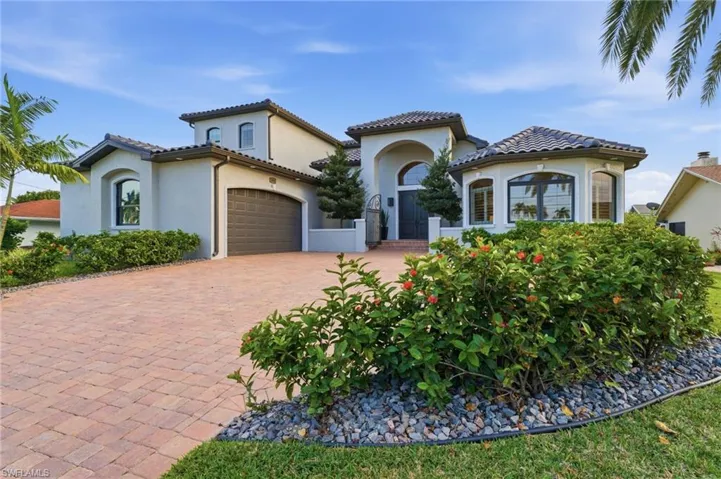 house with stucco siding, decorative driveway, a garage, and a tiled roof