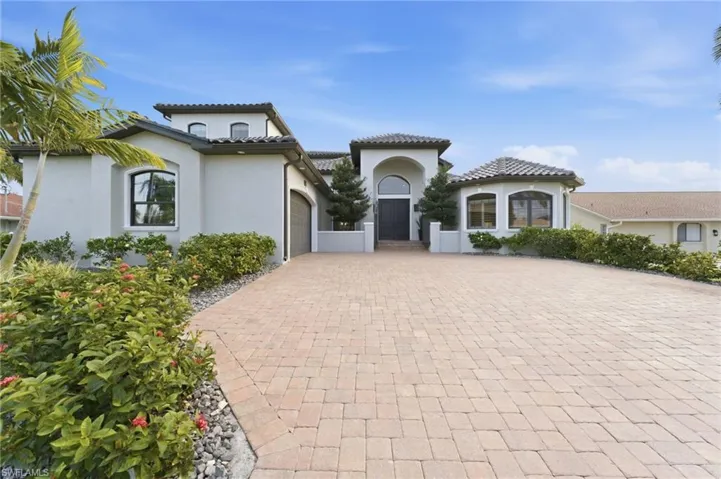 style home featuring an attached garage, stucco siding, driveway, and a tile roof