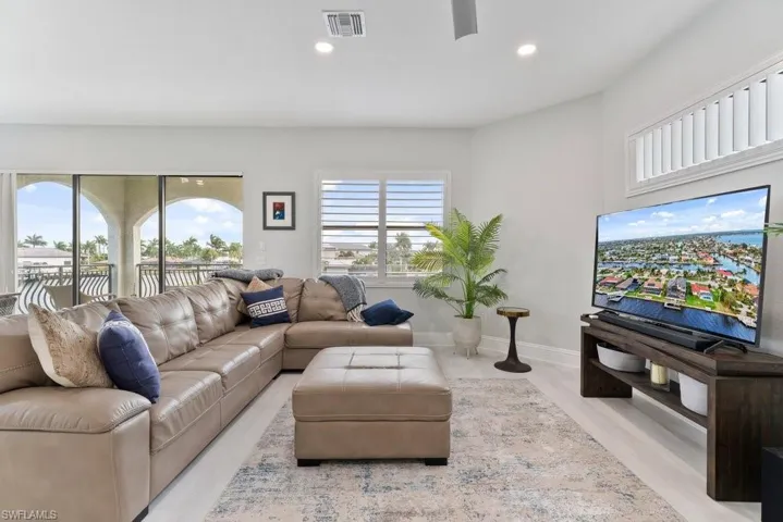 Living room featuring a ceiling fan, light wood-style flooring, and recessed lighting