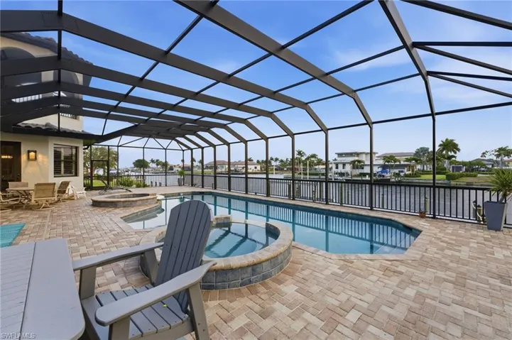 Relaxing pool / spa with a sunroom, a lanai, a patio, a water view, and a residential view
