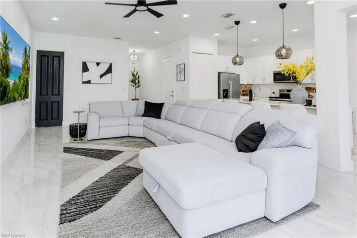 Open-concept living area with tile flooring and recessed lighting