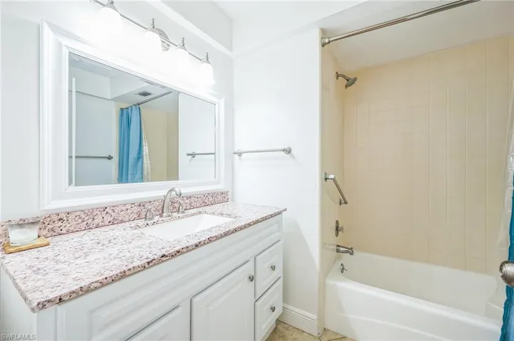 Bathroom with tile patterned floors, vanity, and shower / bath combo